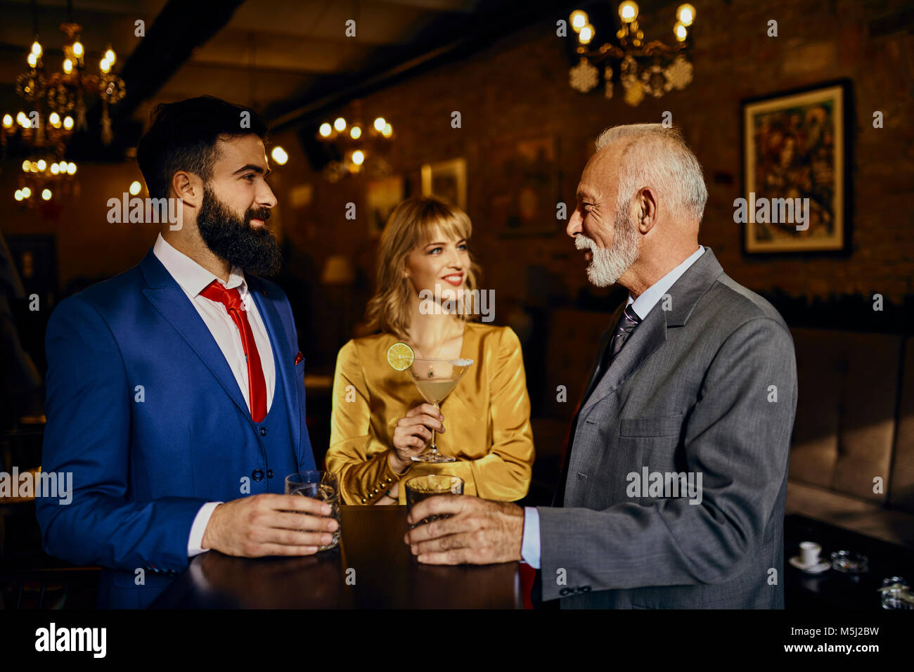 Zwei elegante Männer und Frau Geselligkeit in einer Bar Stockfoto