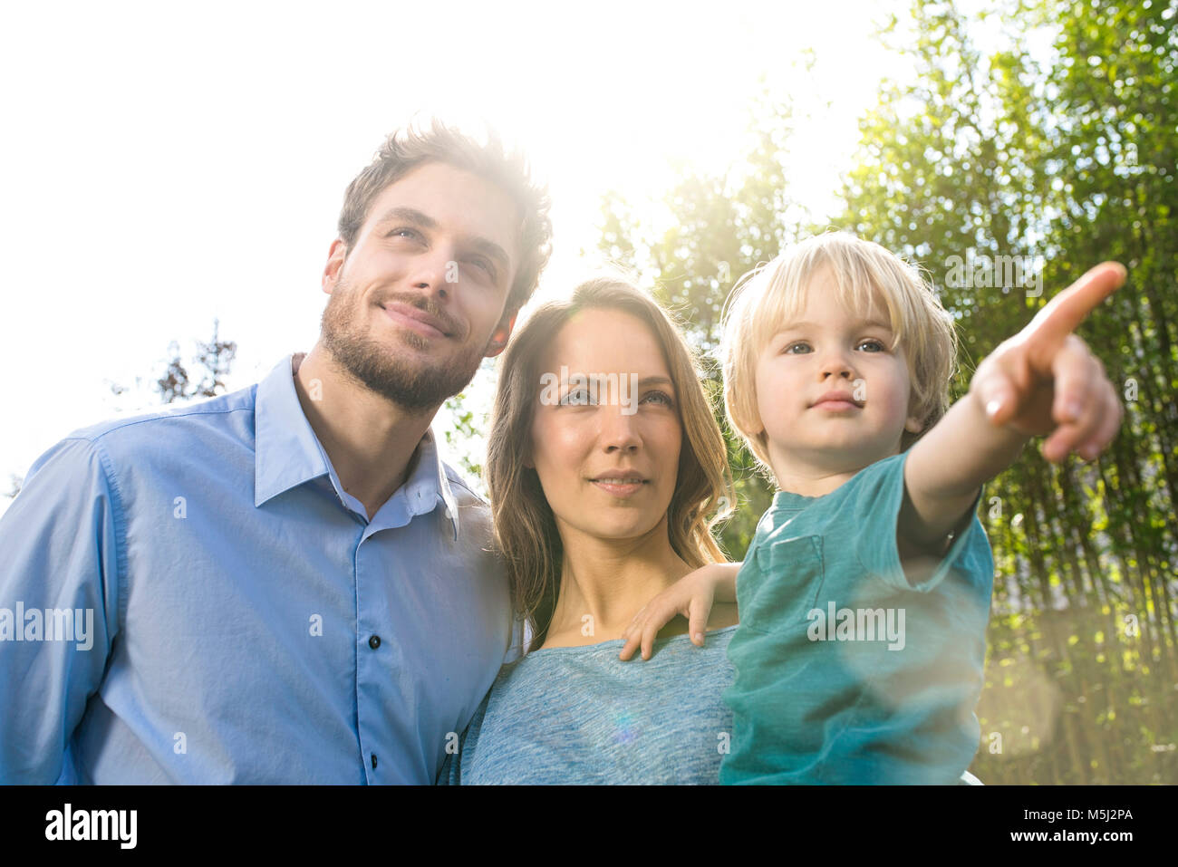 Lchelnde Familie vor Bambus Pflanzen mit Sohn, der seinen Finger  Stockfotografie - Alamy