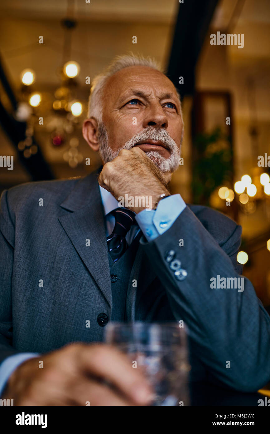 Portrait von eleganten älterer Mann in einer Bar mit Zuhaltung Stockfoto