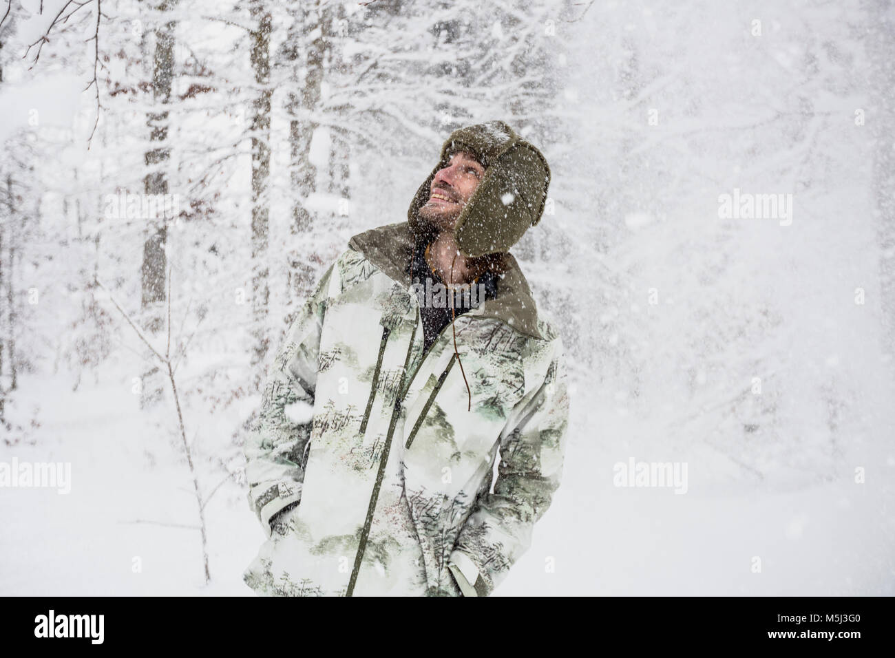 Glückliche Menschen in Camouflage Jacke im Winter Wald Stockfoto