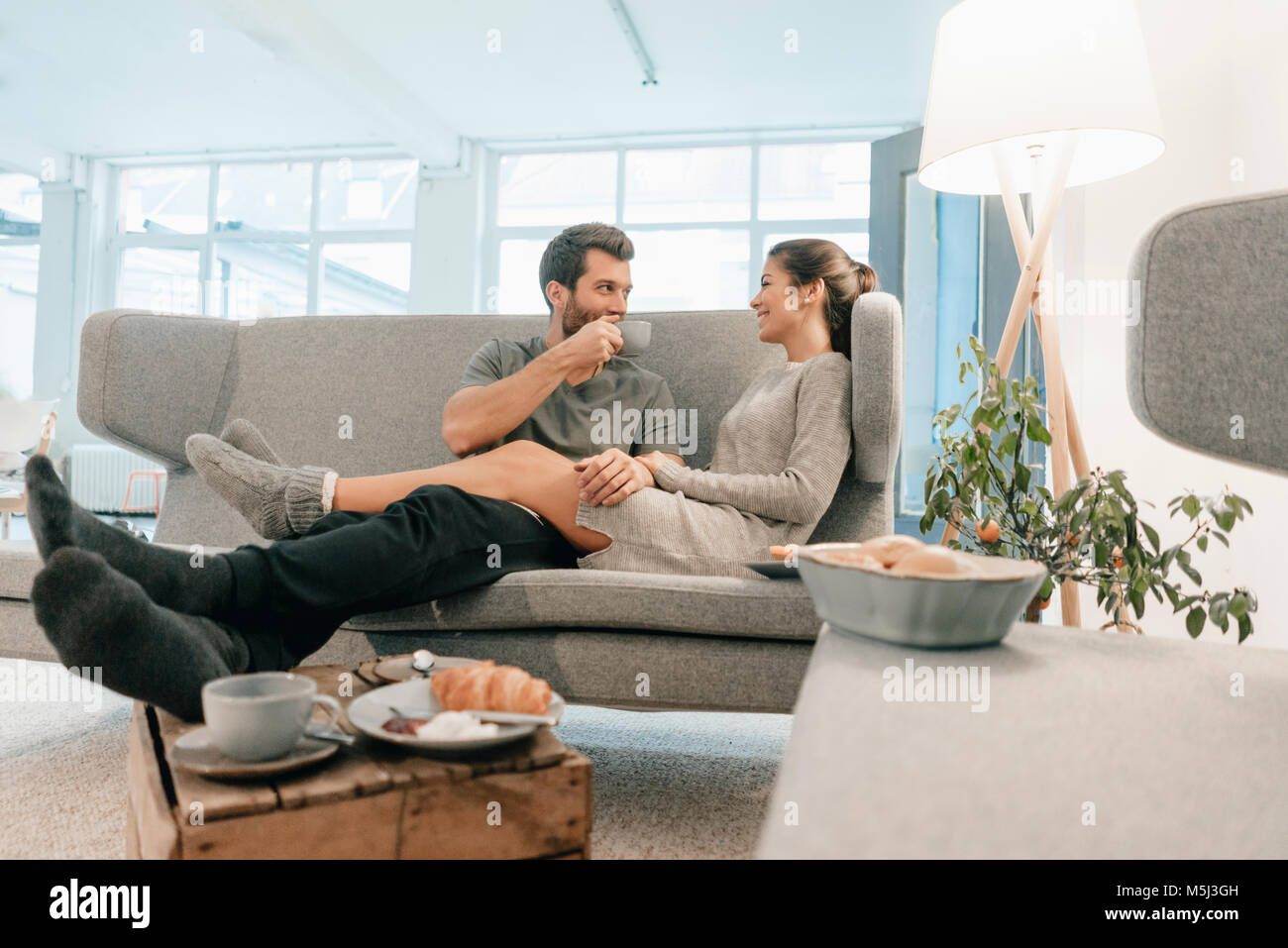 Paar entspannen auf der Couch zu Hause Frühstücken Stockfoto