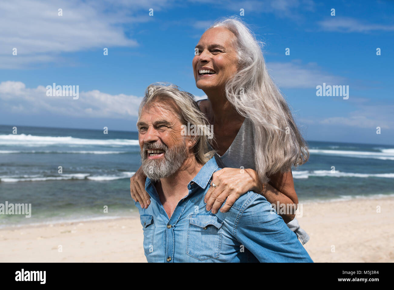 Stattliche senior Paar Spaß am Strand Stockfoto