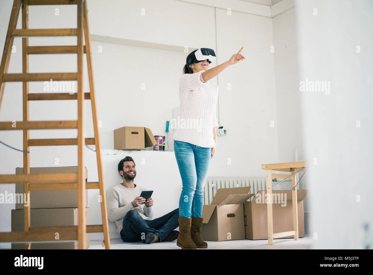 Paar im neuen Haus mit Frau mit VR-Brille Stockfoto