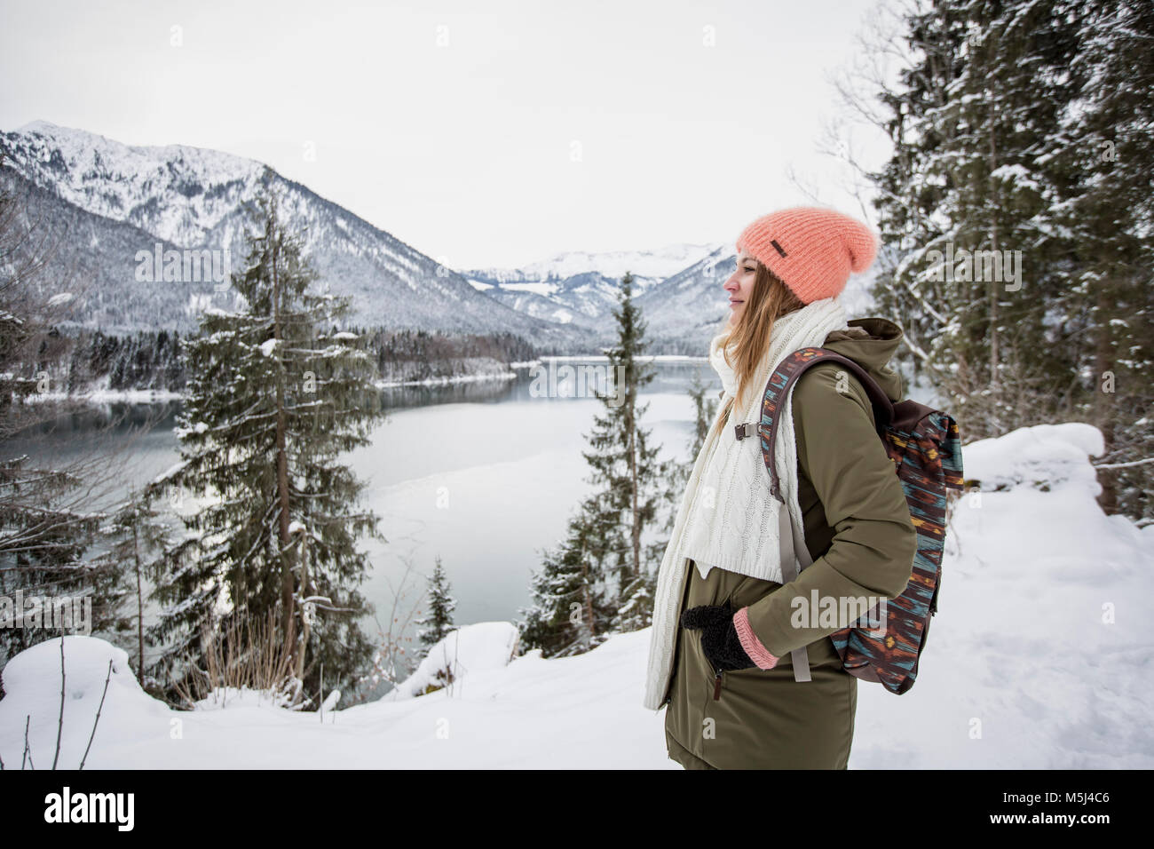 Junge Frau, die in alpinen Winter Landschaft mit See Stockfoto