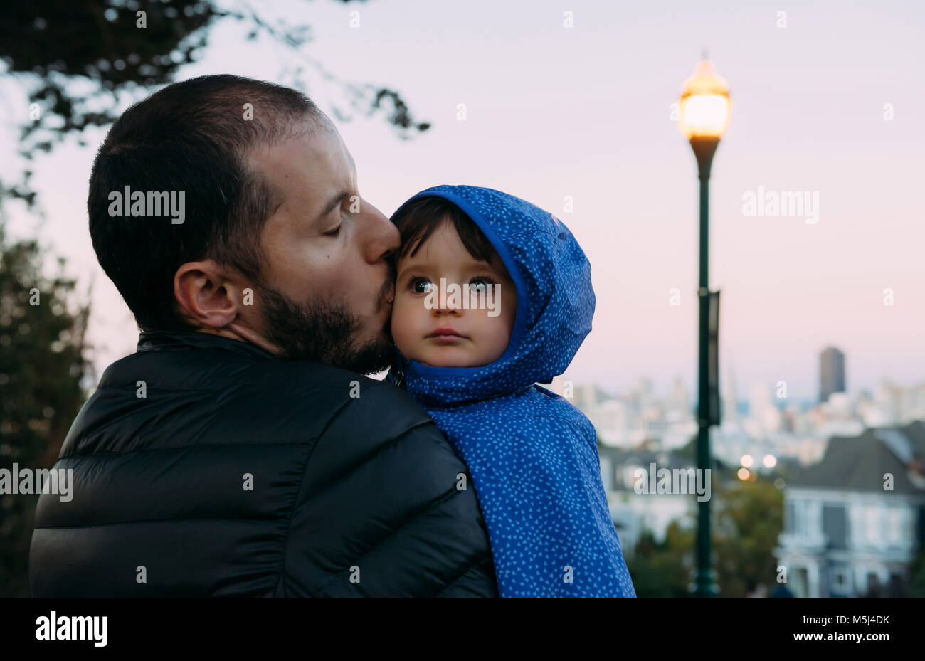 USA, Kalifornien, San Francisco, der Vater küsst ein Baby Mädchen am Alamo Square am Abend Stockfoto