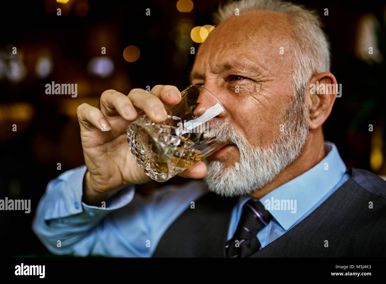 Portrait von eleganten älterer Mann das Trinken aus Becher Stockfoto