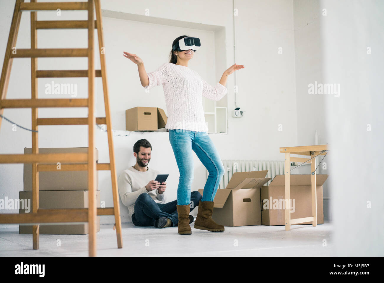 Paar im neuen Haus mit Frau mit VR-Brille Stockfoto