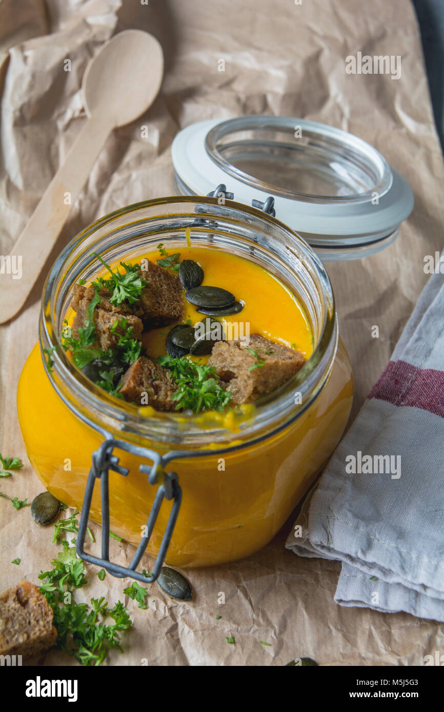 Kürbissuppe mit Croutons, Kürbiskerne, Petersilie in Glas Stockfoto