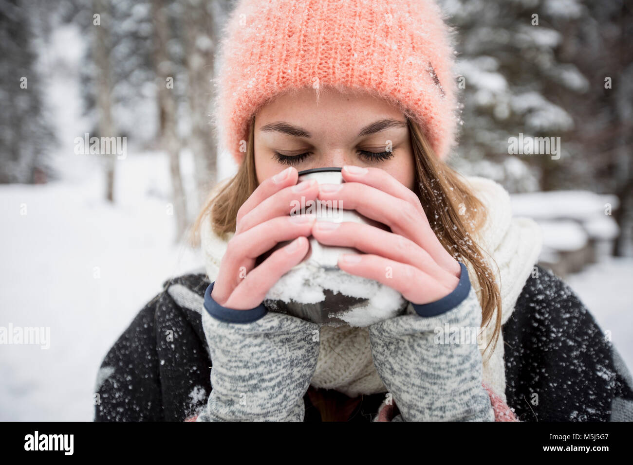 Junge Frau genießen Sie heiße Getränke im Freien im Winter Stockfoto