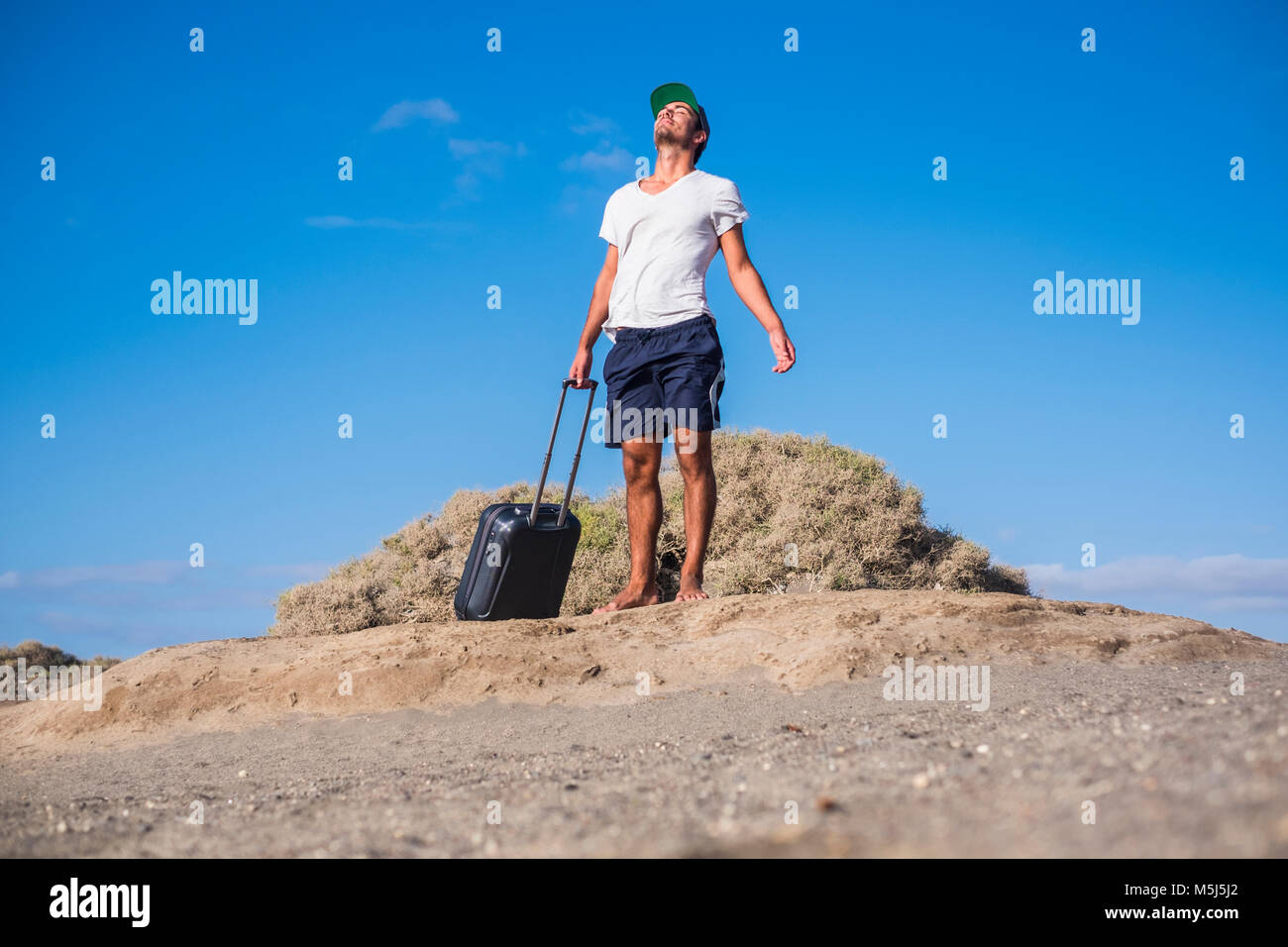 Mann mit rollenden Koffer am Strand Stockfoto