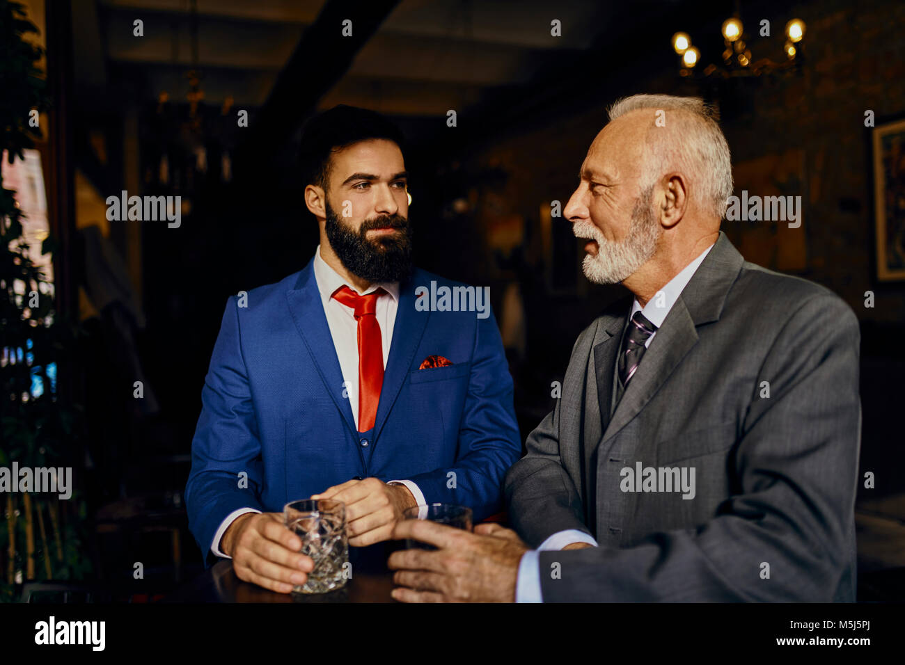 Zwei elegante Männer in einer Bar mit Zuhaltung Stockfoto