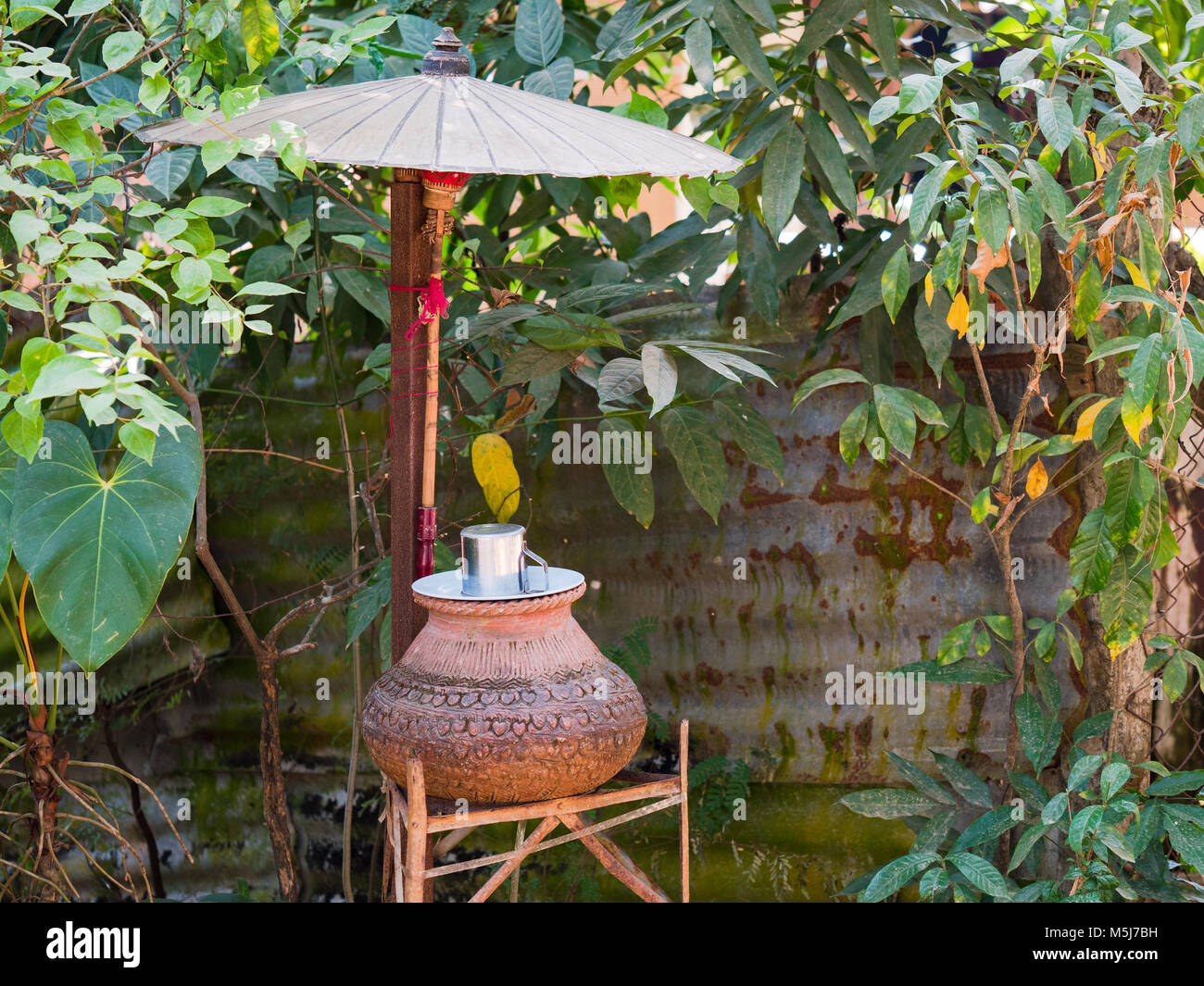 Am Straßenrand jar mit Trinkwasser und ein Metall Becher in Yangon, Myanmar. Diese Gläser sind in den Städten und Gemeinden in Myanmar. Stockfoto