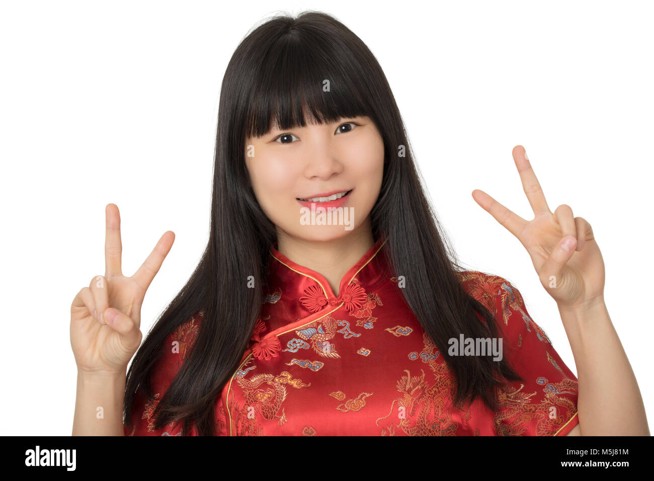 Schöne chinesische Frau das Tragen einer Tracht bekannt als Cheongsam oder Chipao und geben das friedenszeichen Geste isoliert auf einem weißen backgrou Stockfoto