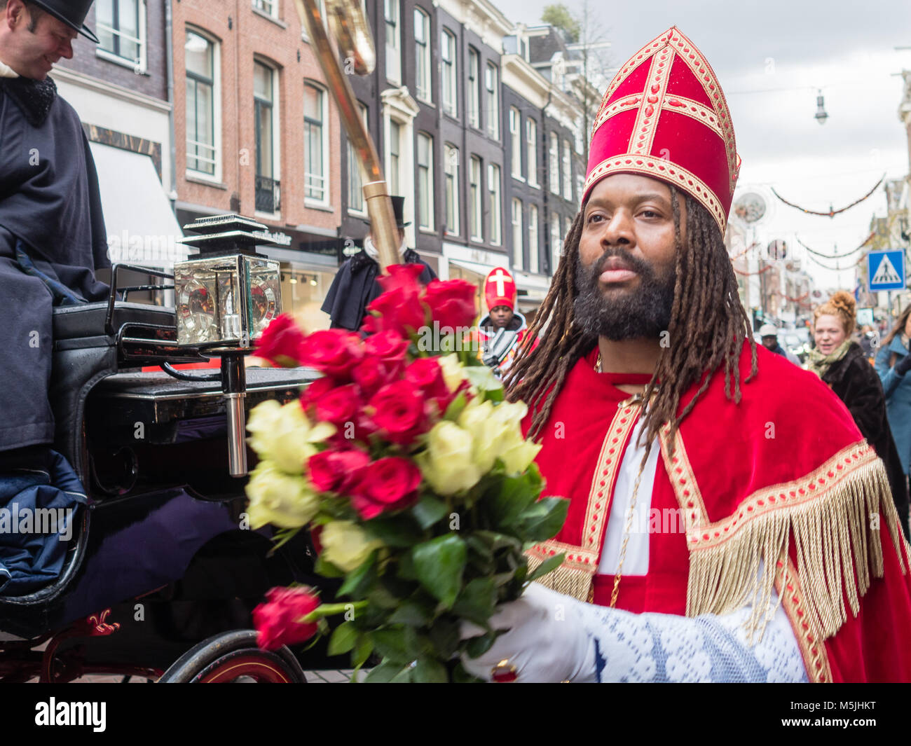 Die "Nieuwe Sint" angeboten rote und weiße Rosen als Botschaft der Liebe, der Freundschaft und des Friedens, und die Frucht, die die Kinder gesund zu leben. Stockfoto