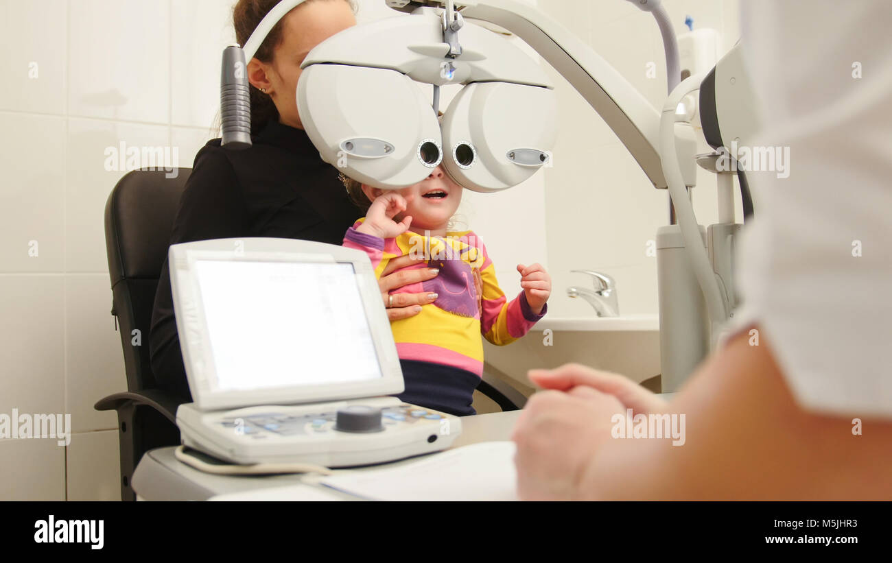 Hohe tehnology in der Medizin - Augenarzt in der Klinik überprüfen der kleinen Mädchen Vision - Kinder und Augenheilkunde Stockfoto