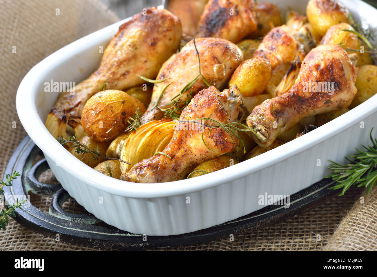 Frisch aus dem Ofen: gebackene Chicken Drumsticks mit kleinen Kartoffeln und Zwiebeln Stockfoto
