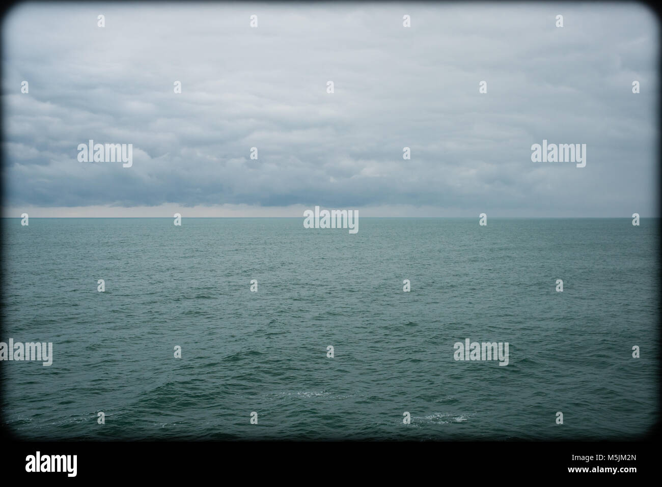 Leere offene Meer Ozean in kalten grauen Farben mit Vintage matt Effekt und Vignette Grenze Stockfoto