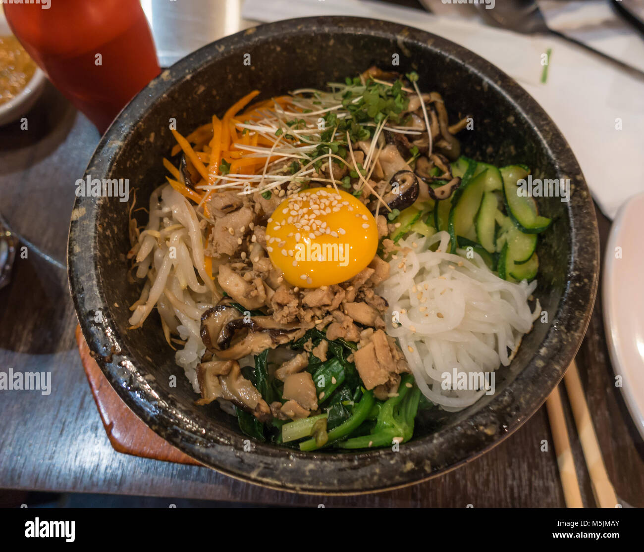 Bibimbap ist eine Südkoreanische Teller Reis mit Gemüse und einer Sauted roh oder Spiegelei. Stockfoto Bibimbap ist eine Südkoreanische Teller Reis mit Gemüse und einer Sauted roh oder Spiegelei. Stockfoto