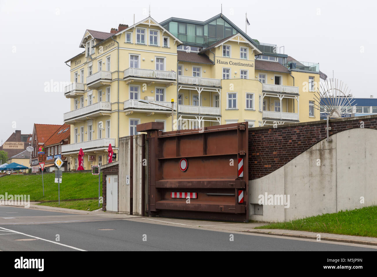 Hotel Cuxhaven mit Stahltür im Deich für Gewässerschutz Stockfoto