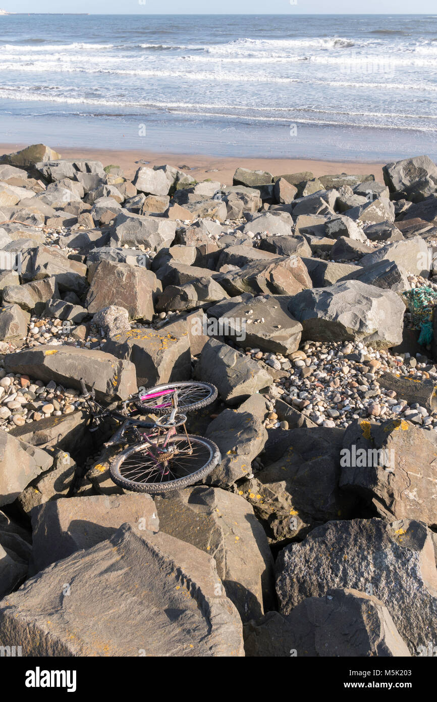 Abgebrochene Fahrrad auf Felsen am Meeresufer Seaton Carew, Hartlepool, Cleveland, England, Großbritannien Stockfoto