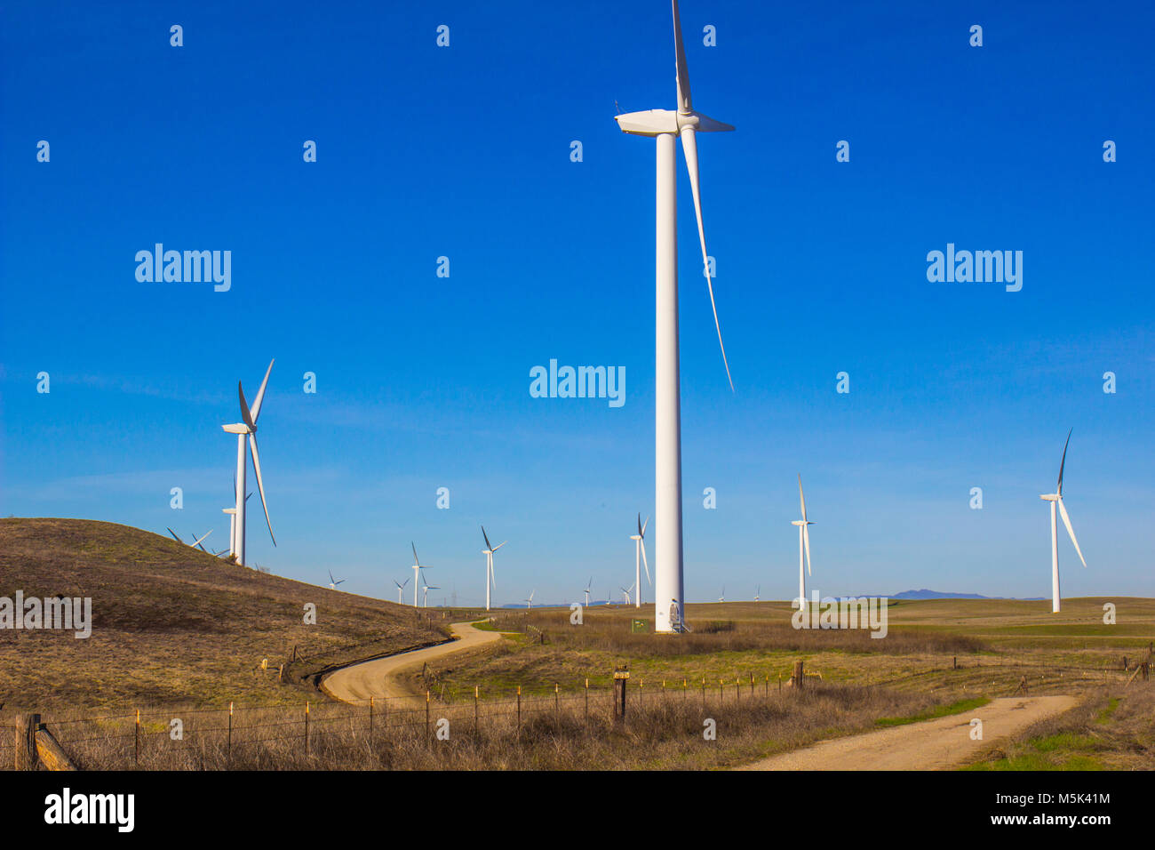 Feld von drei länglichen Energie produzierenden Windmühlen Stockfoto