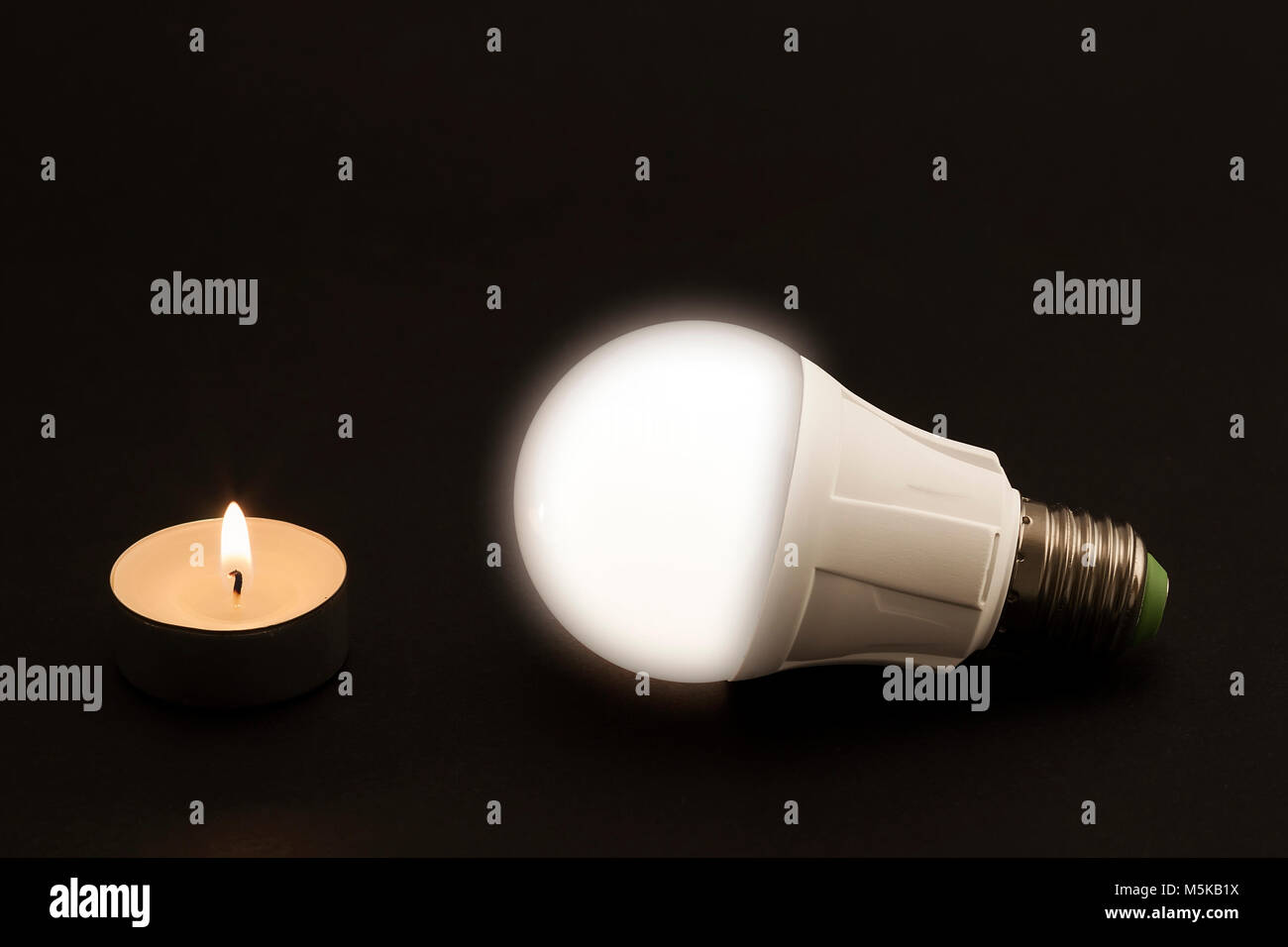 Fortschritte bei der Beleuchtung mit Kerze angezeigt und LED-Lampe.  Entwicklung der Beleuchtung, der Konfrontation verschiedener Generationen  von Lichtquellen. Moderner Techno Stockfotografie - Alamy