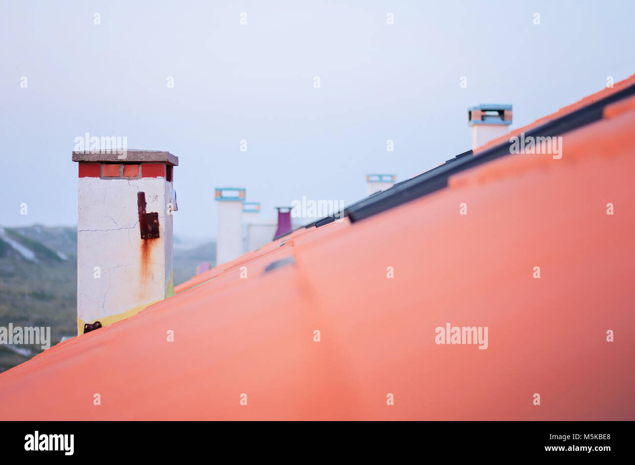 Schornsteine in einer Reihe auf Roten Tonziegeln Dachterrasse Stockfoto