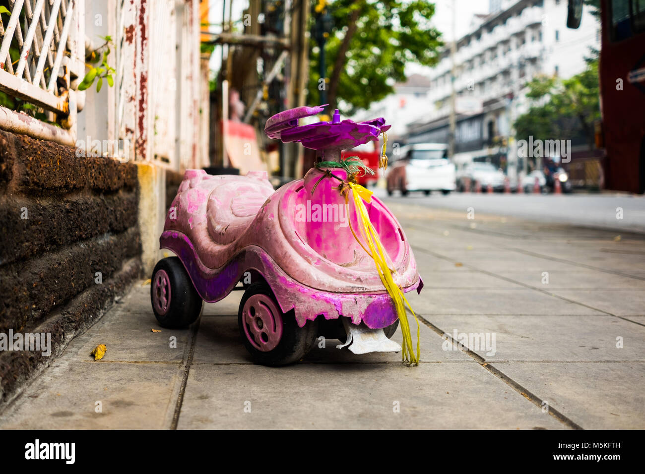 Das alte Spielzeug Auto für Kinder auf dem Bürgersteig in der Stadt, selektive konzentrieren. Stockfoto