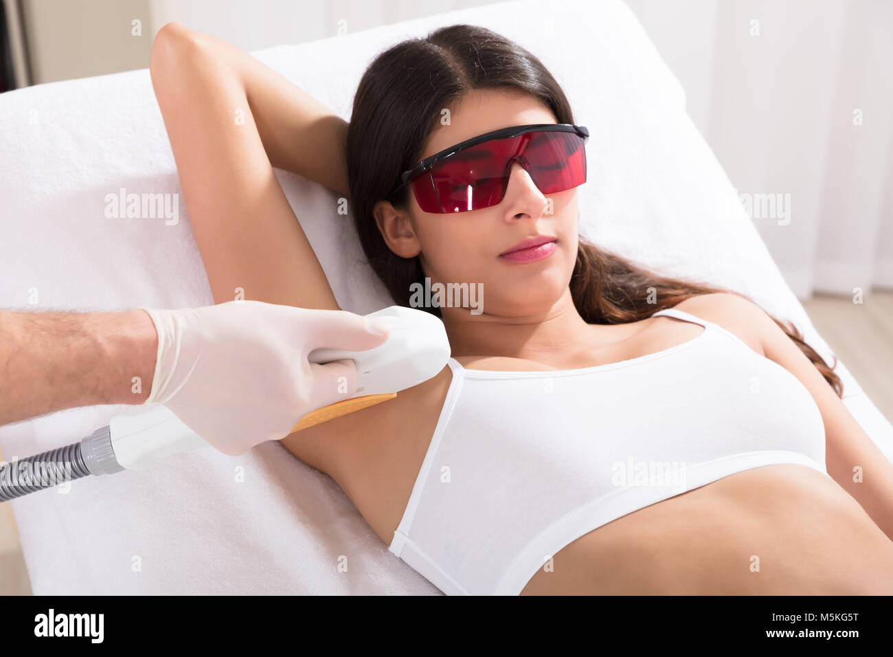Junge Frauen, die Laserepilation Behandlung der Achselhöhlen in Spa. Stockfoto