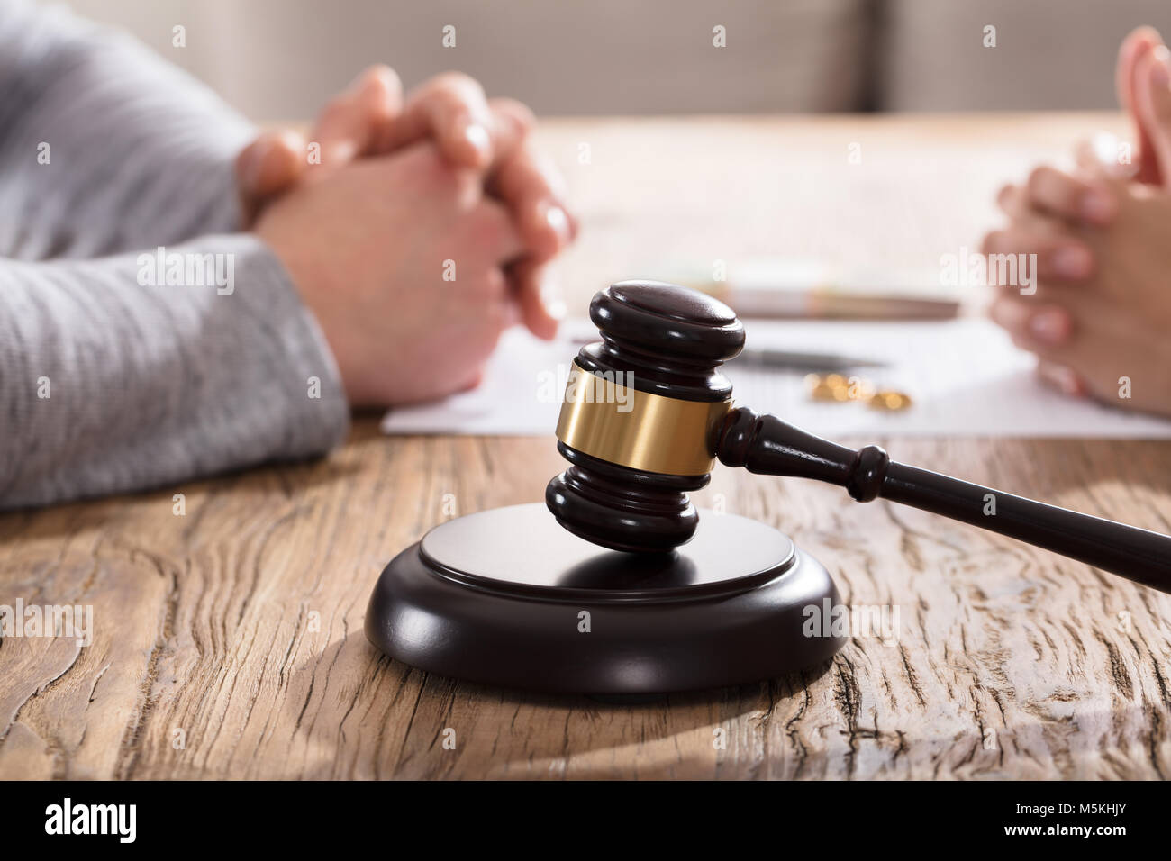 Hammer Vor Paar Hand auf hölzernen Tisch Stockfoto