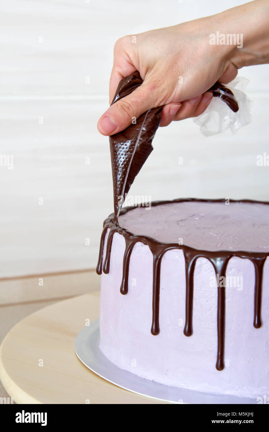 Konditor in der Küche dekorieren ein Kuchen Schokolade Stockfoto