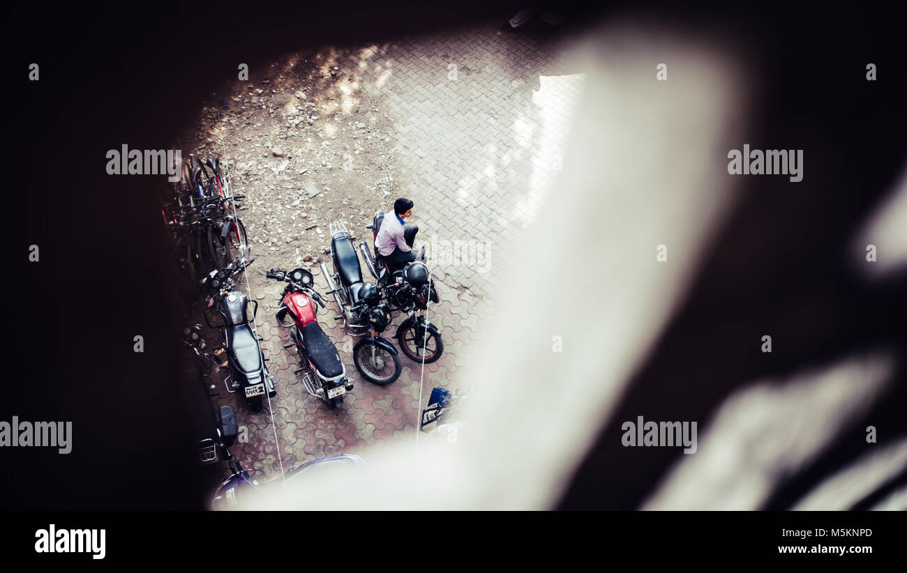 Mann auf einem Motorrad auf einem Parkplatz in Mumbai, Indien sitzen Stockfoto