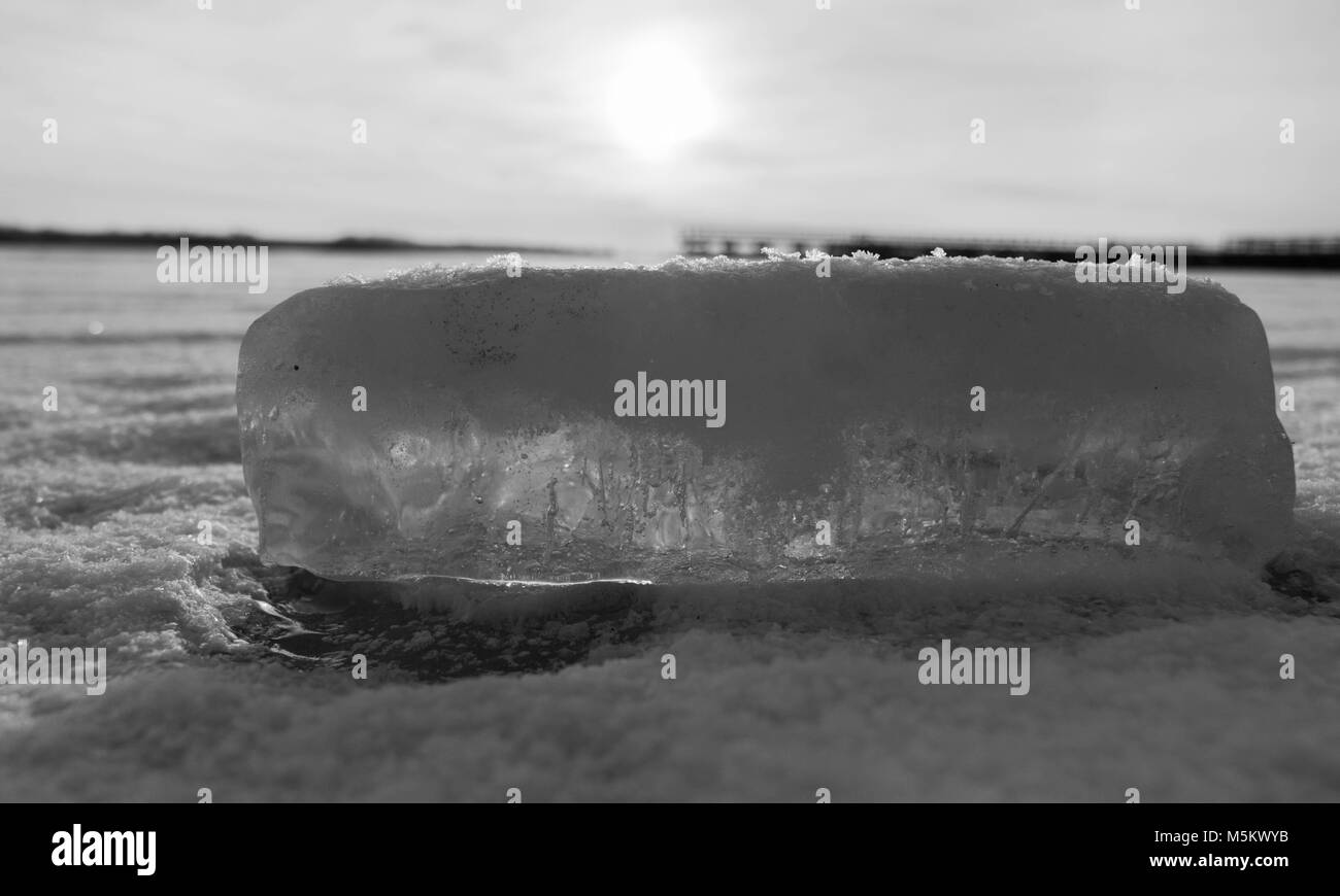 Ice brick Festlegung auf dem gefrorenen Ake, am Morgen Sonnenstrahlen im Winter gefroren scheint Stockfoto