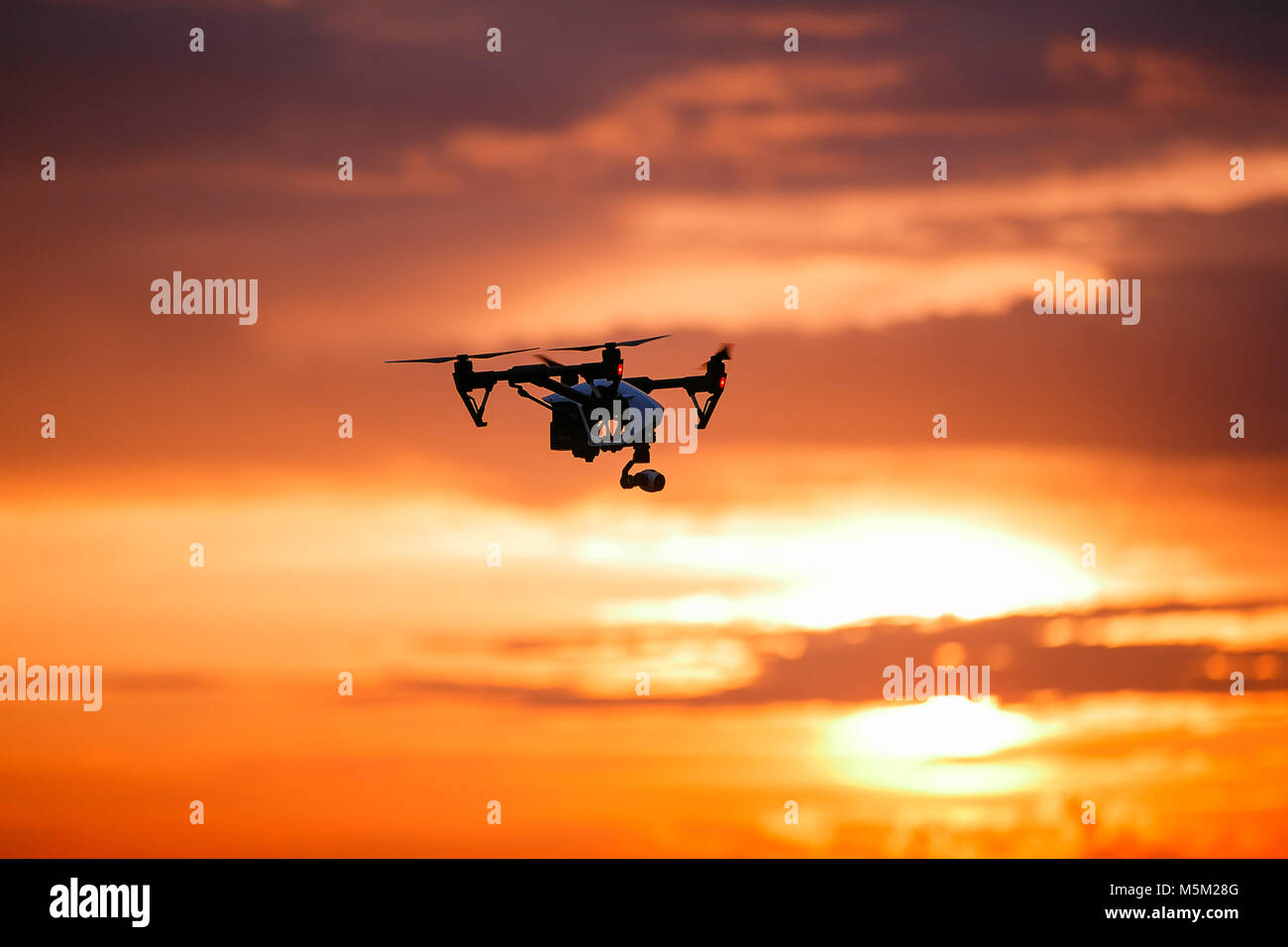 Quadrocopter Drohne mit Fernbedienung. Dunkle Silhouette gegen Colorfull Sonnenuntergang. Soft-Fokus. Getönten Bild Stockfoto