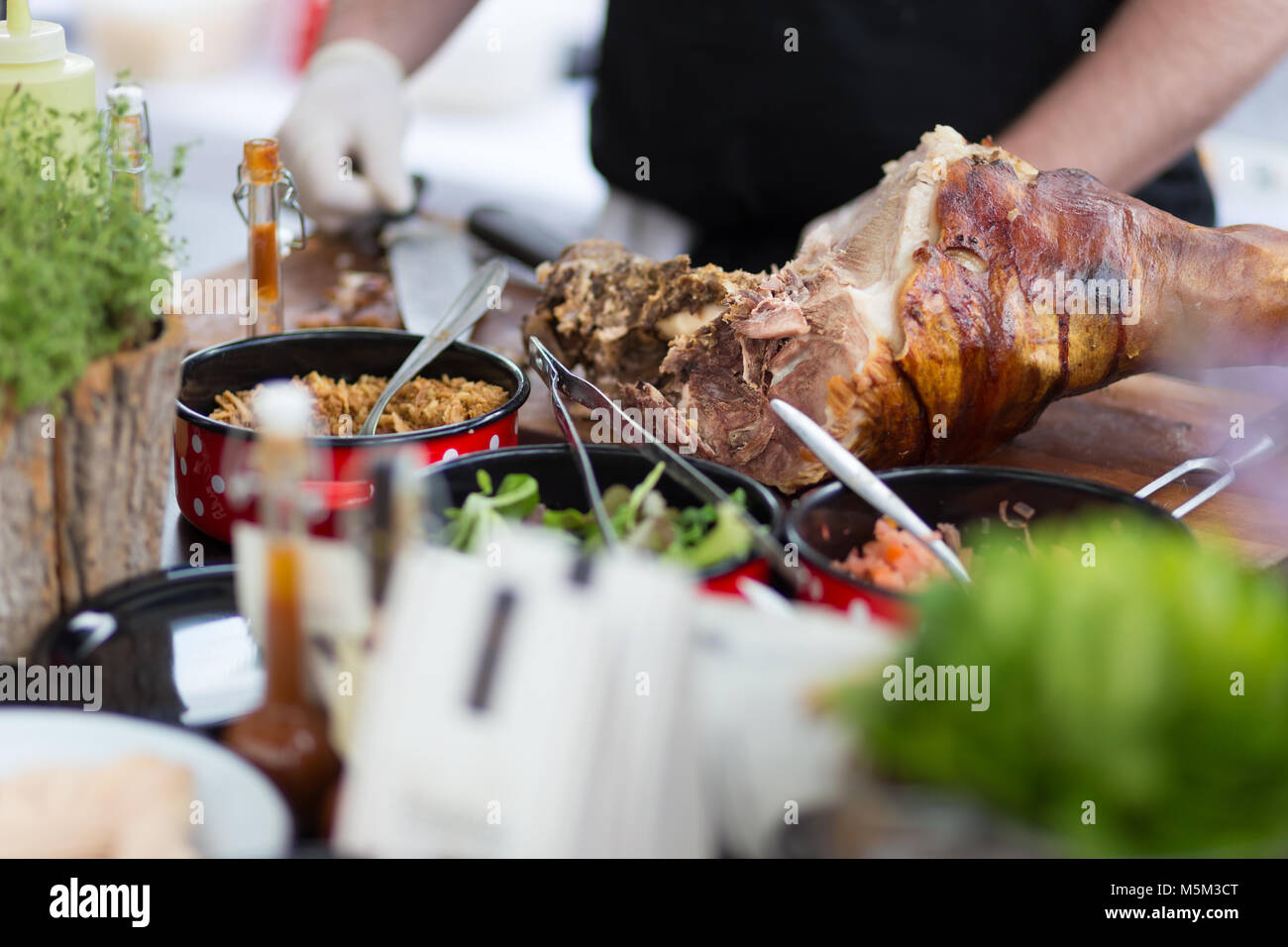 Cheff mit traditioneller Fleischgericht auf Straße Street Food Festival, Ljubljana, Slowenien. Stockfoto