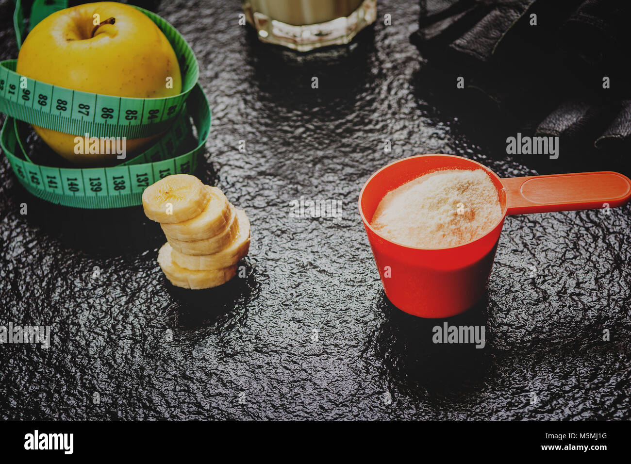 Protein Pulver in Schaufel und Früchte auf steinernen Tisch Stockfoto