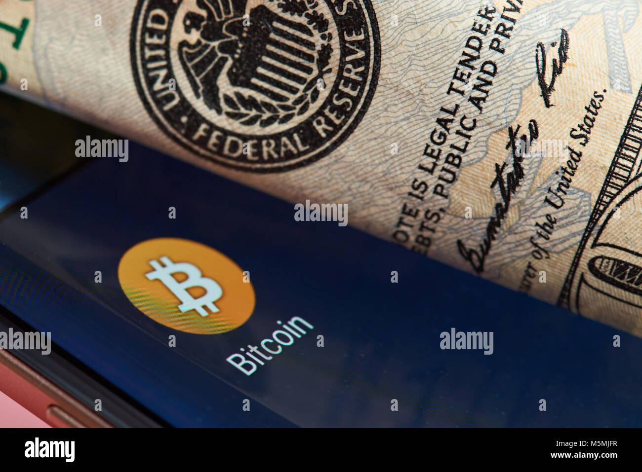 New York, USA - 26. Juni 2017: Bitcoin gegen Dollar System. Bitcoin Smartphone-anwendung close-up gegen Federal Reserve System. Stockfoto