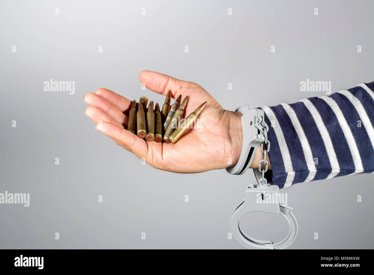 Handschellen und Munition. Konzept der strafrechtlichen Handlungen und die Munition in seinem Besitz. Stockfoto