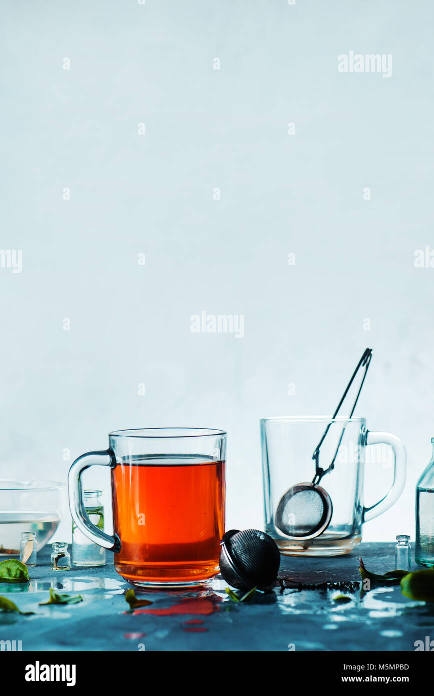 Tasse Tee und eine leere Tasse mit einem Sieb auf hellem Hintergrund mit kopieren. High-key Feder vibes Still life Konzept. Stockfoto