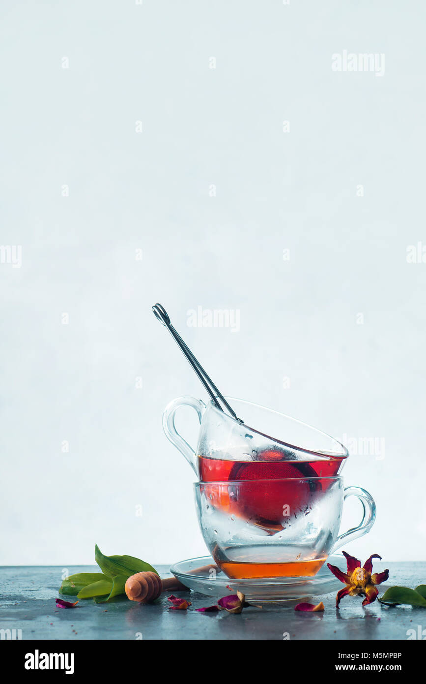 Teetassen mit einem Sieb, Schweißen und grüne Blätter auf einem weißen Hintergrund. Transparenz und Frische Konzept, Hintergrundbeleuchtung, Szene mit kopieren. Stockfoto