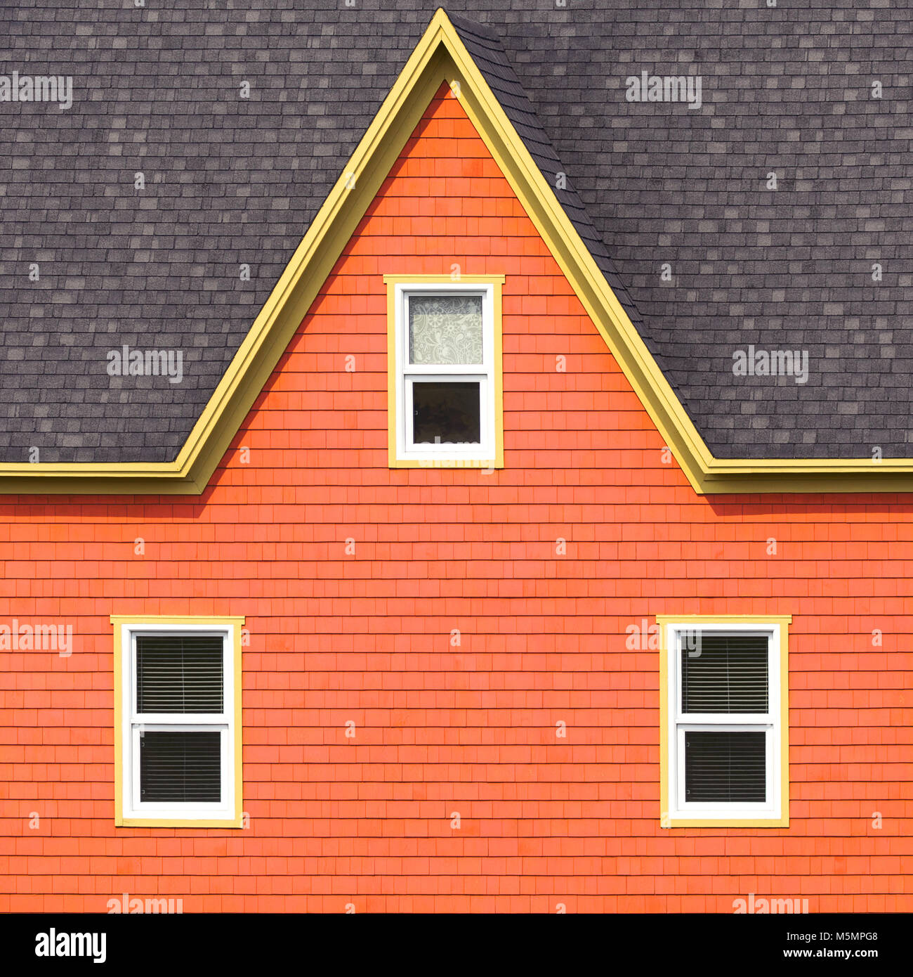 Dach grau, orange Schindel Wände mit gelben und weißen Details. Minimalistischer Stil. Stockfoto