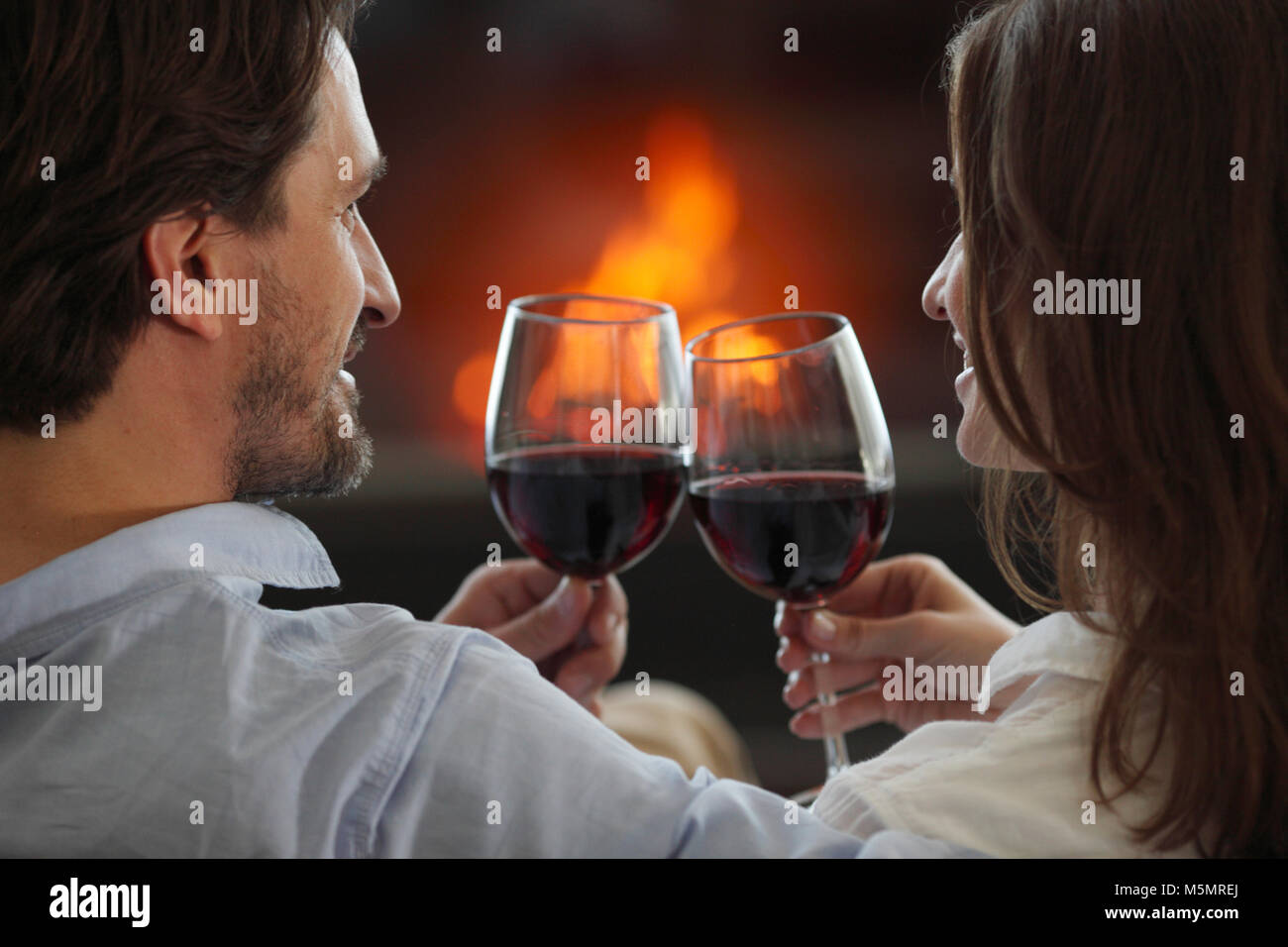 Romantisch zu zweit trinken Wein zu Hause in der Nähe von Kamin  Stockfotografie - Alamy