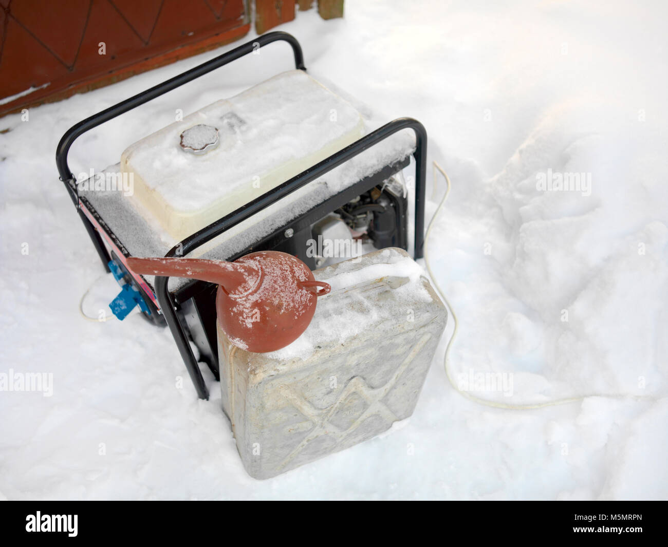 Oben Blick auf ein Stromgenerator, Kanister und Trichter auf dem Schnee Stockfoto