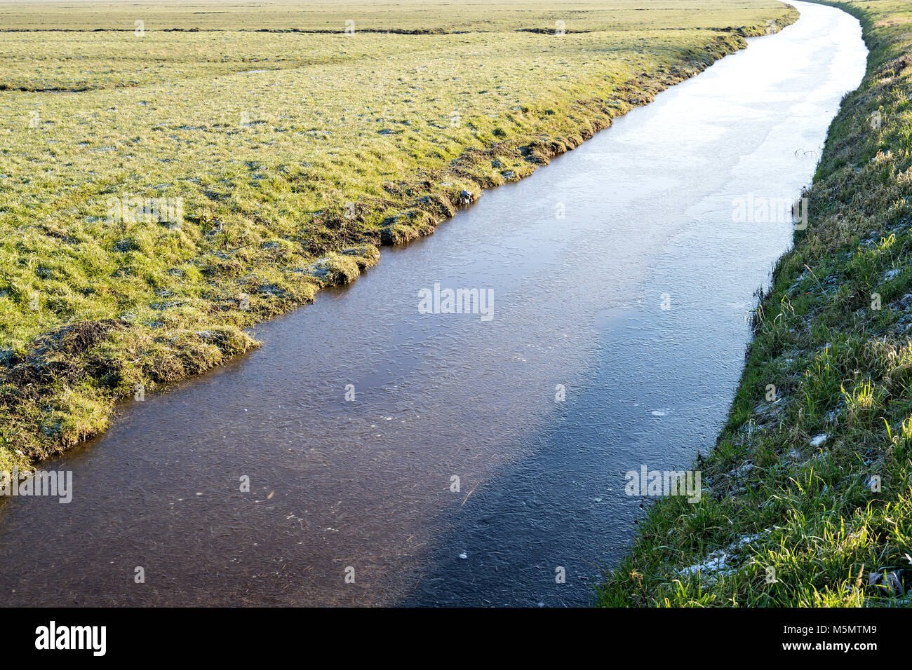 Halb erfroren Entwässerungskanal in Niederländisch Flächeninhalt Landschaft Stockfoto