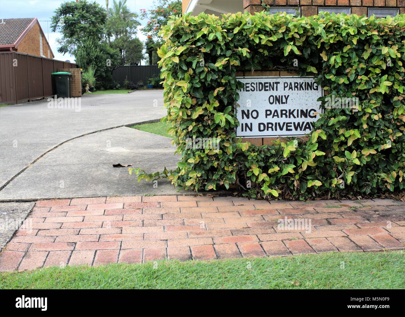 Schild "Resident Parken nur. Kein Parkplatz in der Auffahrt." Zeichen an der Wand außerhalb der Auffahrt. Stockfoto