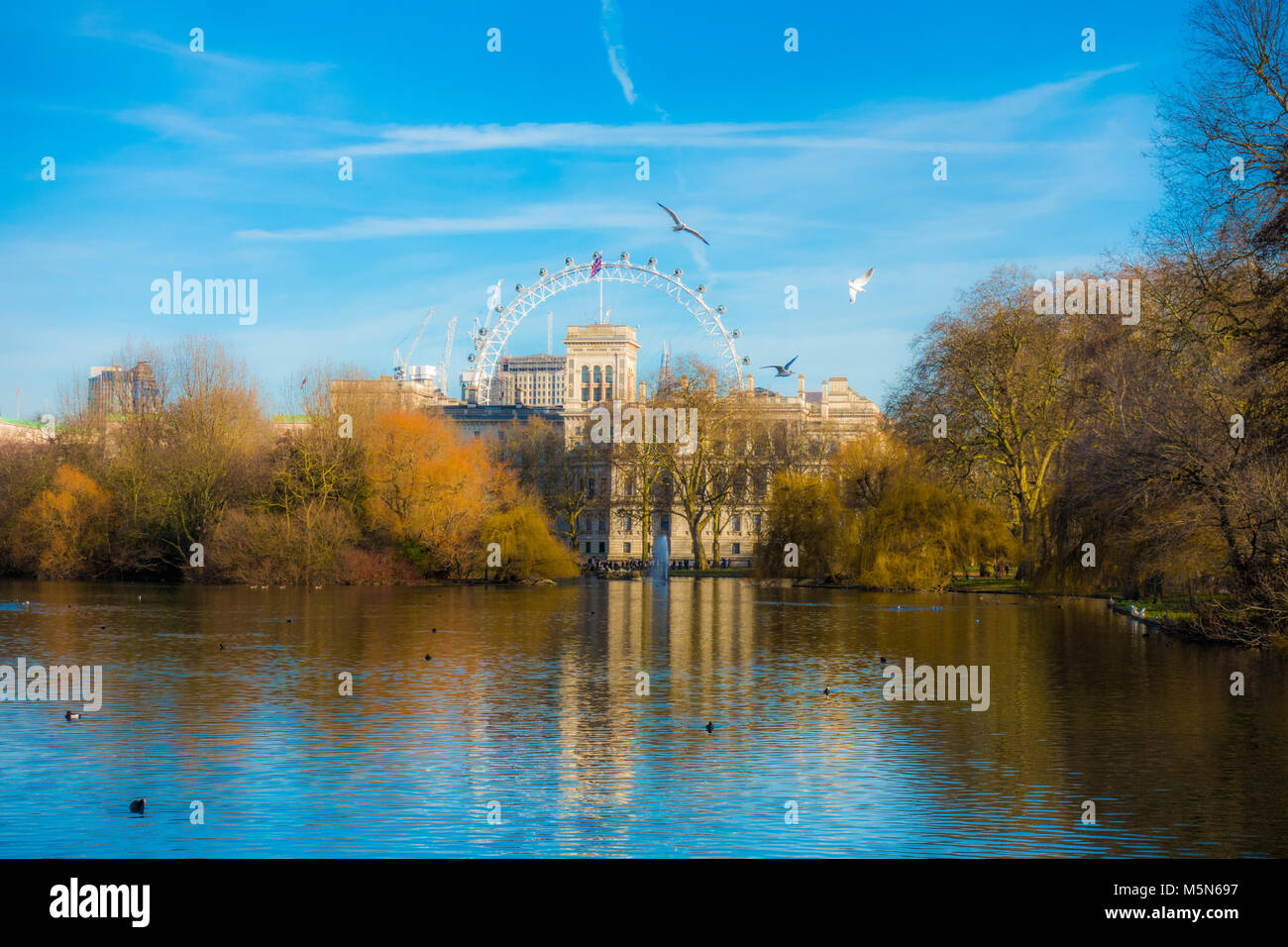 Schönen warmen Winter licht Blick auf das London Eye und Horse Guards Road Gebäude, die aus über den See im St James's Park, London SW1A, England, UK. Stockfoto