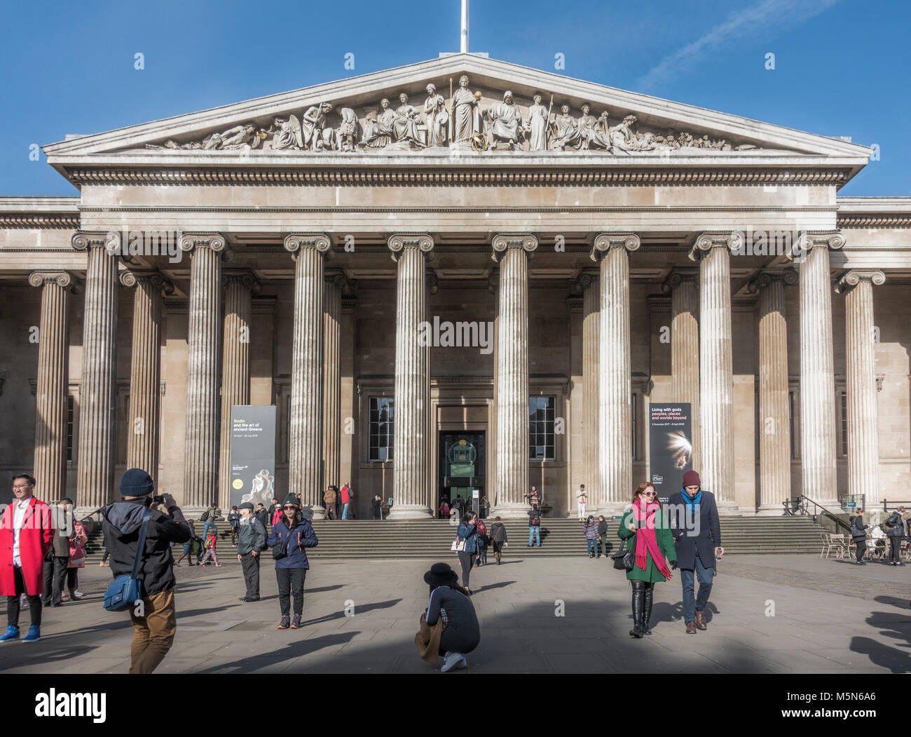 Haupteingang des British Museum (für die menschliche Geschichte, Kunst und Kultur), mit den Besuchern, die im Winter die Sonne. London, England, UK. Stockfoto