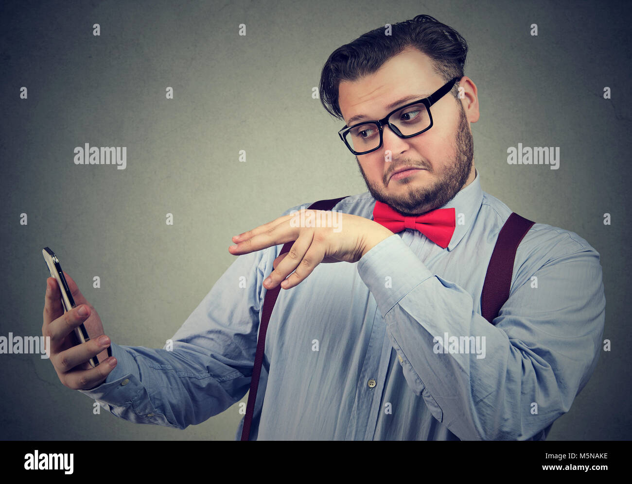 Junge Geschäftsmann in Gläsern Manipulationen mit Gadget smart phone mit Magic Stockfoto