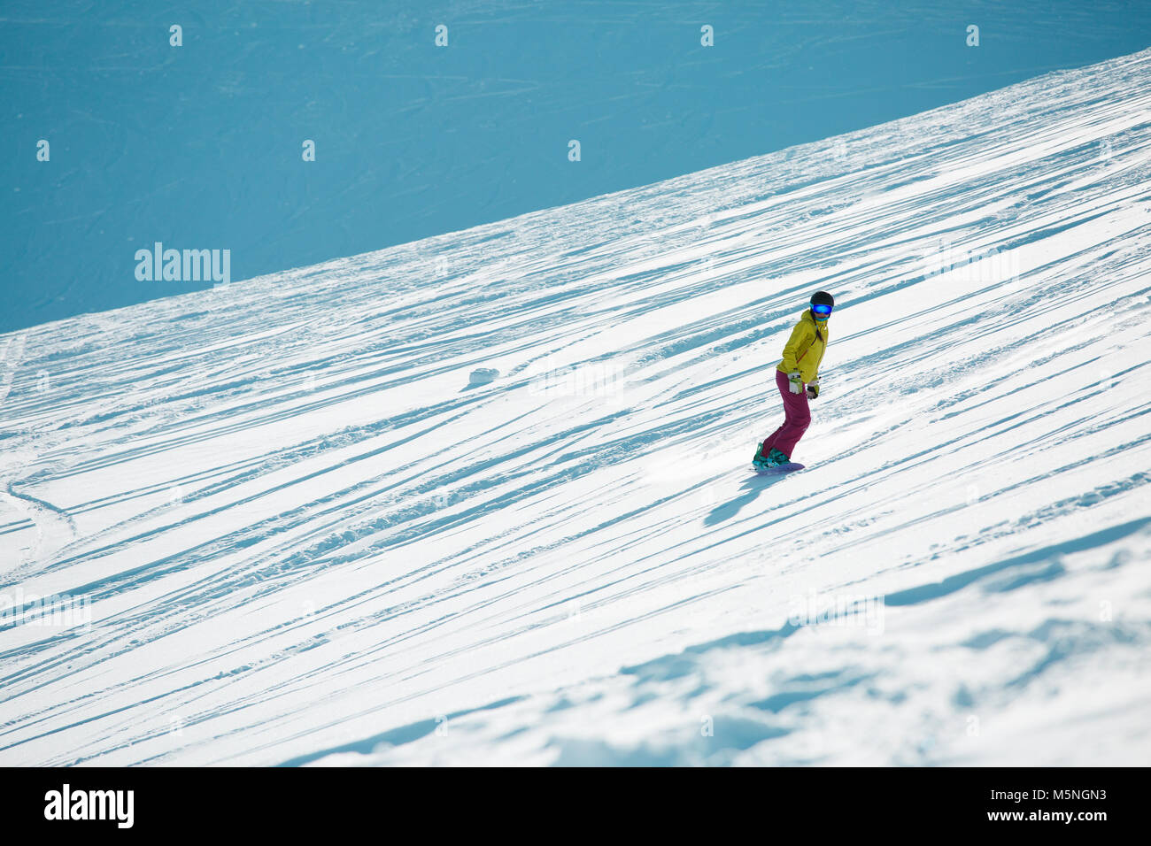 Bild von Sport Mädchen das Tragen von Helm und Maske, Snowboarden vom Berghang im Winter Stockfoto