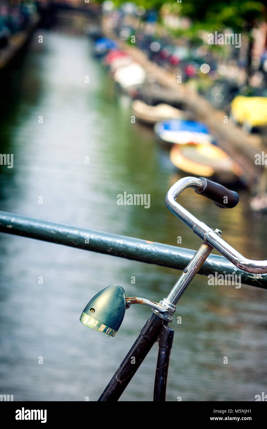 Lenker Fahrrad mit einer Lampe nach unten poiting zwischen den Kanälen und Brücken von Amsterdam, Holland, Niederlande Stockfoto